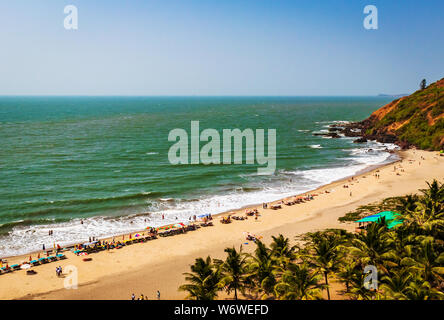 Blick von oben auf den Strand in Goa Indien Vagator Beach. Leute, die Sonnenbad am Strand auf Hütten Stockfoto