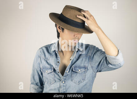 Porträt Mann in Jeans Shirt oder Jeans Shirt Art und Weise berührt hat. Denim Jeans Hemd oder T-Shirt Mode für Männer auf grauem Hintergrund Stockfoto
