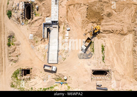 Antenne Blick von oben auf die industriellen Bagger und Kipper bereitet Boden für den Bau der Straße Stockfoto