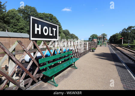 Blick auf die grüne Bank und Zeichen bei Holt Station auf dem North Norfolk Eisenbahn Stockfoto