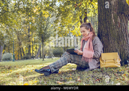 Wirkliche Geschäftsfrau mit Tablet Notebook bei der Arbeit im Freien in Park Stockfoto