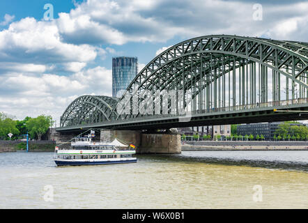 Köln, Deutschland - 12. Mai: Passagierschiff Kreuzung Hohenzollernbrücke in Köln, Deutschland, am 12. Mai 2019. Blick auf Triangle Turm. Stockfoto