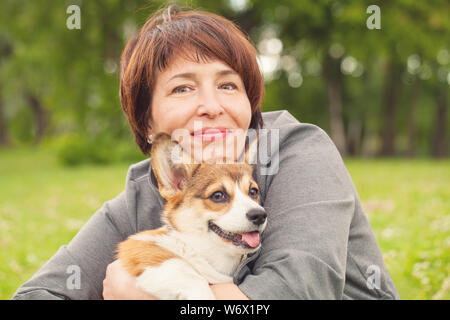 Wunderschöne reife Frau mit corgi Hund Haustier im Sommer Park Stockfoto