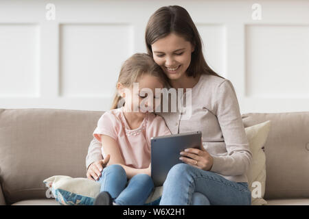 Mutter und Tochter sitzen am Tisch Spaß mit Tablet Stockfoto
