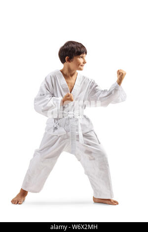 Volle Länge Schoß eines Jungen im Kimono praktizieren Kampfkunst auf weißem Hintergrund Stockfoto