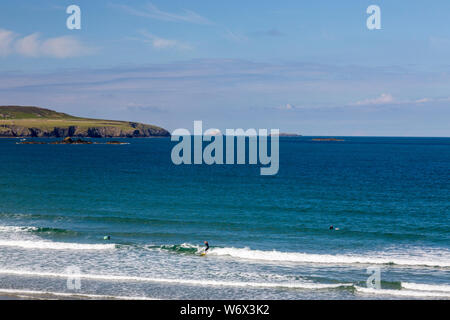 Surfer im Whitesands Bay mit Südafrika Bischof Leuchtturm und Ramsay Insel jenseits, Pembrokeshire Coast National Park, Wales, Großbritannien Stockfoto