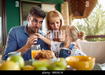 Adorable Kind füttert ihr Vati mit gesicherten Stick Stockfoto