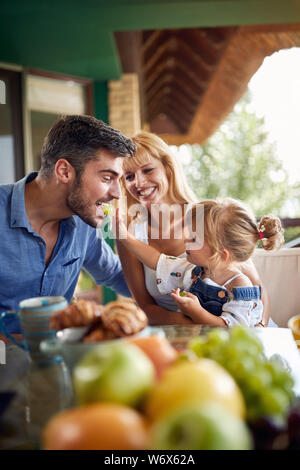 Adorable kleine Weibchen füttert Vater mit Trauben Stockfoto