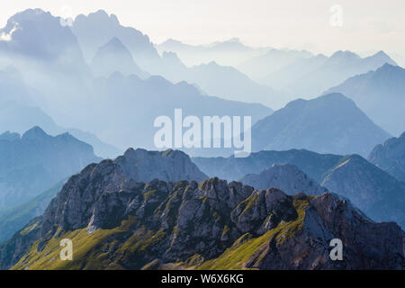 Schichten von Silhouetten von Bergketten und Gipfel in den Alpen, bei Sonnenuntergang. Blick von der Route von Mangart (mangrt) Peak, die Julischen Alpen, T Stockfoto