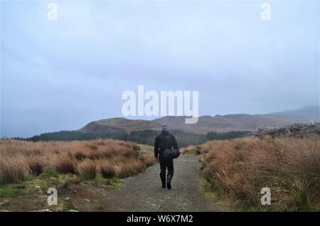 Man Walking in nebligen Landschaft auf der Isle of Skye, Schottland. Stockfoto