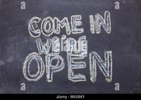 Kommen wir haben geöffnet. Chalk Schriftzug auf der Tafel. Mehrfarbige Inschrift auf einer Schiefertafel Stockfoto
