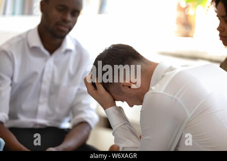 Unterschiedliche Menschen während der Gruppe Therapie konzentrieren sich auf verzweifelte kaukasischen Typ Stockfoto