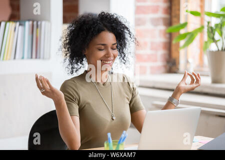 Afrikanische Frau am Tisch in Arbeitsplatz sitzen tun Sie Yoga Übung Stockfoto