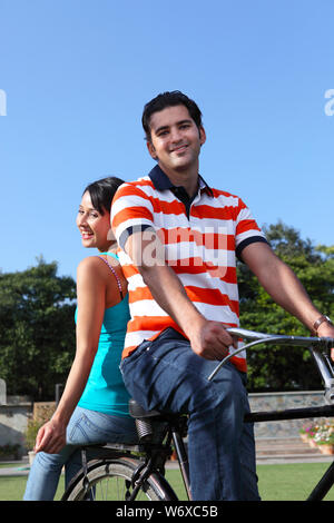 Junges Paar Reiten auf dem Fahrrad in den park Stockfoto