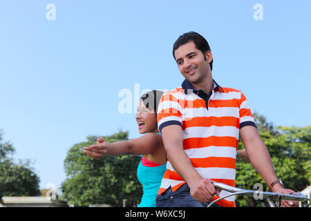 Junges Paar Reiten auf dem Fahrrad in den park Stockfoto