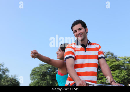 Junges Paar Reiten auf dem Fahrrad in den park Stockfoto