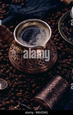 Frisch türkischen Kaffee in alten rustikalen cezve auf Kaffeebohnen Hintergrund Stockfoto