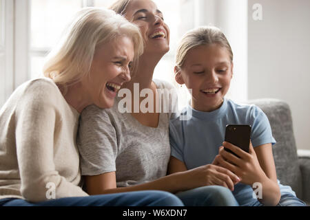 Lachend drei Generationen von Frauen Spaß mit Smartphone Stockfoto