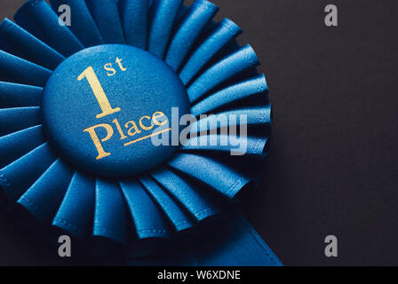 Meister Platz 1 blaue Rosette mit gold Text auf schwarzem Hintergrund Stockfoto