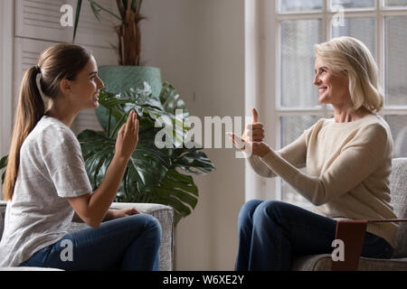 Aufgewachsen Tochter sprechen Sie mit älteren Mutter mit Zeichensprache Stockfoto