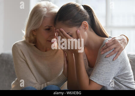 Während die Erwachsenen Tochter weinend im mittleren Alter Mutter ausdrücken Empathie Stockfoto