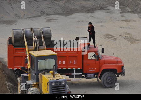 Eine weibliche LKW-Fahrer überwacht die Beladung Ihres Fahrzeugs in Nantong China Stockfoto