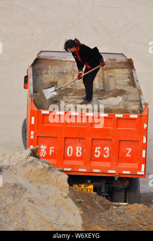 Eine weibliche LKW-Fahrer überwacht die Beladung Ihres Fahrzeugs in Nantong China Stockfoto