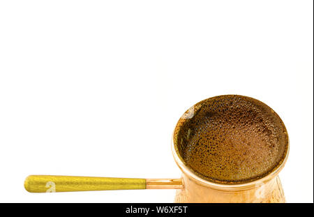 Hausgemachte frisch gekocht starken Kaffee in der türkischen Messing cezve Topf auf weißem Hintergrund. Stockfoto