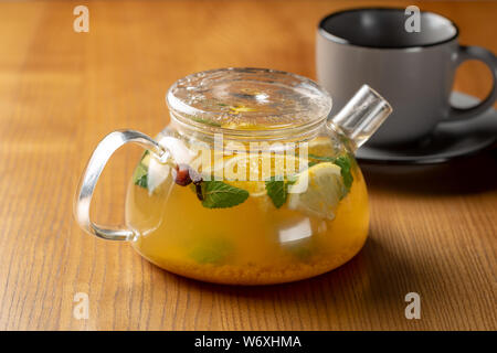 Hot orange mit Pfefferminztee im Glas Wasserkocher Stockfoto