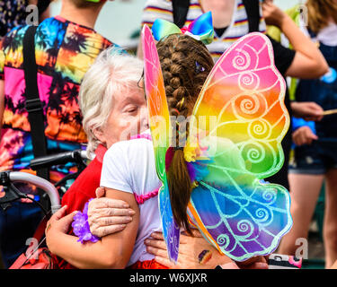 Brighton, East Sussex, UK. 3 Aug, 2019. Brighton, UK. 03 Aug, 2019. Ein junges Mädchen in Rainbow Schmetterling Kostüm hugs ihre Großmutter während Brighton Pride Parade auf Hove Rasen, Brighton, East Sussex, UK. Brighton Pride Parade auf Hove Rasen, Brighton, East Sussex, UK. 3. August 2019 Foto: Julia Claxton/Alamy leben Nachrichten Stockfoto