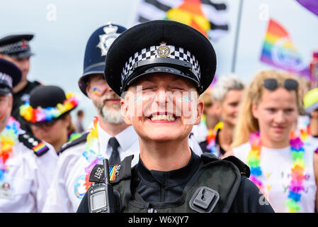 Brighton, East Sussex, UK. 3 Aug, 2019. Ein glückliches Polizist grinst während Brighton Pride Parade auf Hove Rasen, Brighton, East Sussex, UK. 3 Aug, 2019. Photo Credit: Julia Claxton/Alamy leben Nachrichten Stockfoto