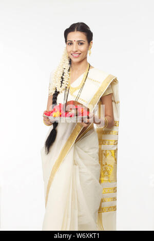 South Indian woman holding Puja thali und lächelnd Stockfoto