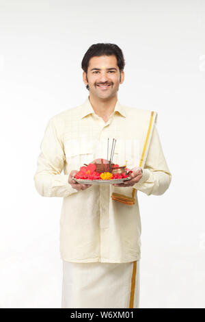 Südindische Mann hält Puja thali Stockfoto