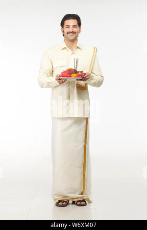 Südindische Mann hält Puja thali Stockfoto