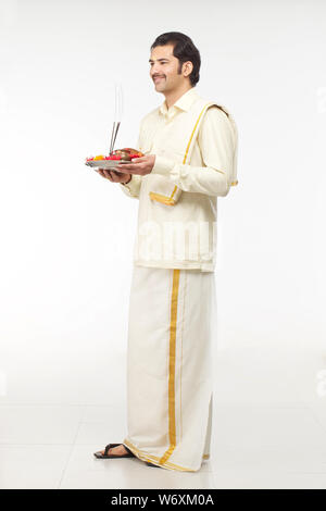 Südindische Mann hält Puja thali Stockfoto