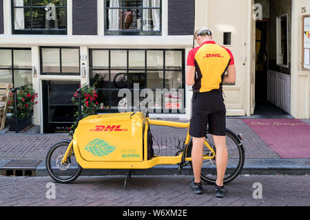 DHL-Kurier mit Fracht Fahrrad. DHL ist eine Abteilung des Deutschen Logistikunternehmen Deutsche Post AG Die International Express Mail Service. Stockfoto