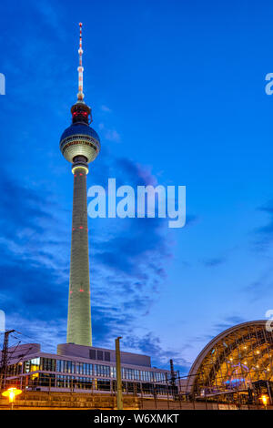 Den berühmten Berliner Fernsehturm und dem Bahnhof am Alexanderplatz in der Nacht Stockfoto