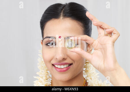 Südindische Frau zeigt zehn Rupie-Münze Stockfoto