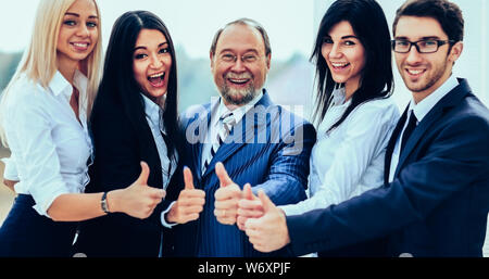 Erfolgreiche freundlich Business Team auf Büro Hintergrund alle Daumen nach oben Stockfoto