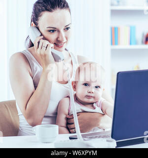 Junge Mutter und mit Laptop mit grandma über Skype zu kommunizieren, zu Hause im Kinderzimmer baby Stockfoto