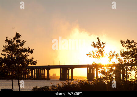 FEUER AM HIMMEL: Ein explosiver und dramatischer Sonnenuntergang entsteht durch die Verschmutzung durch eine nahegelegene Fabrik und natürliche atmosphärische Bedingungen. Stockfoto