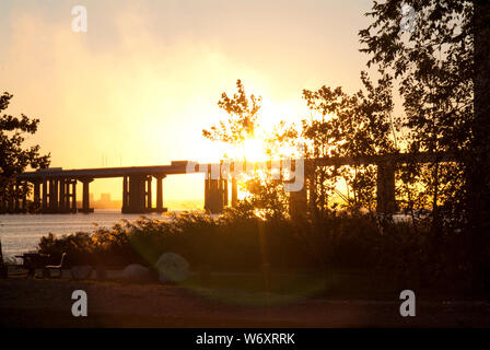 FEUER AM HIMMEL: Ein explosiver und dramatischer Sonnenuntergang entsteht durch die Verschmutzung durch eine nahegelegene Fabrik und natürliche atmosphärische Bedingungen. Stockfoto