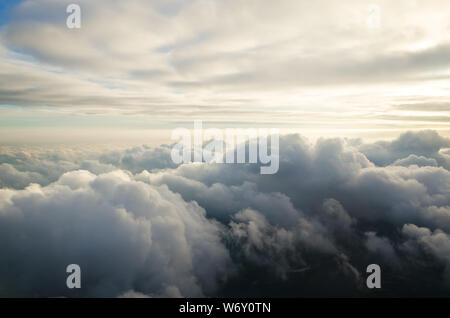 Wolken und Himmel, als durch das Fenster eines Flugzeugs zu sehen. Über den Wolken Stockfoto