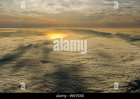 Wolken und Himmel, als durch das Fenster eines Flugzeugs zu sehen. Über den Wolken Stockfoto