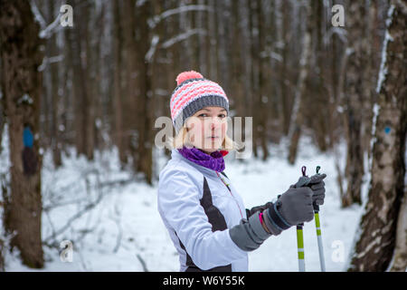 Foto der lächelnde Frau mit Skiern im Winter Wald auf unscharfen Hintergrund Stockfoto