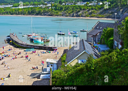 Einen ruhigen Blick auf den schönen Strand in Newquay mit Fischerbooten in den Schutz der Mole vor Anker. Familien spielen auf Sandstrand. Stockfoto