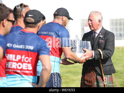 Der Prinz von Wales, bekannt als The Duke of Rothesay, während in Schottland, präsentiert einen Preis von einem Fall von Bier auf die Hilfe für Helden Team, das Tauziehen um das Mey Highland & Kulturelle Spiele gewonnen, die auf der John O' Groats Showground in Caithness. Stockfoto