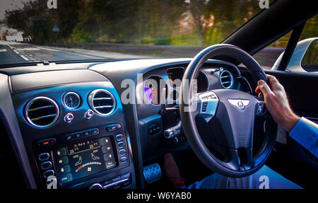 Autofahrer mit einer Hand am Lenkrad eines Bentley Continental GTC Supersport Stockfoto