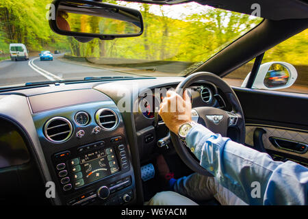 Autofahrer mit einer Hand am Lenkrad eines Bentley Continental GTC Supersport Stockfoto