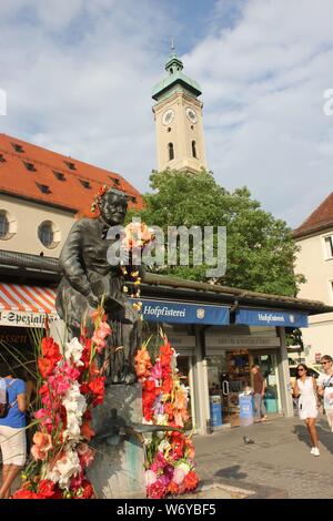 Berühmte Trinkwasser Brunnen in München, Viktualienmarkt. Elise Aulinger Brunnen, geschmückt mit Blumen am Brunnenfest. Stockfoto